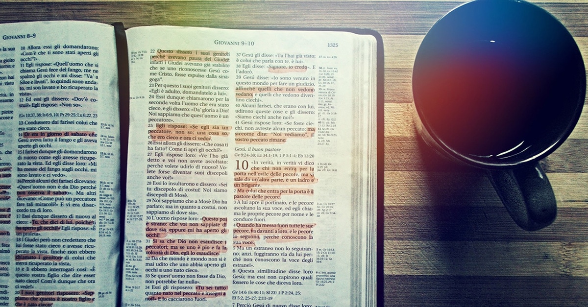 Laid open bible with coffee cup