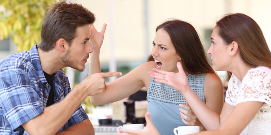 Two women arguing with man