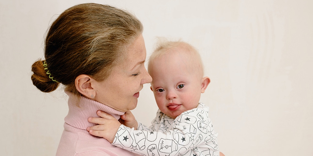 Mom holding baby with down syndrome