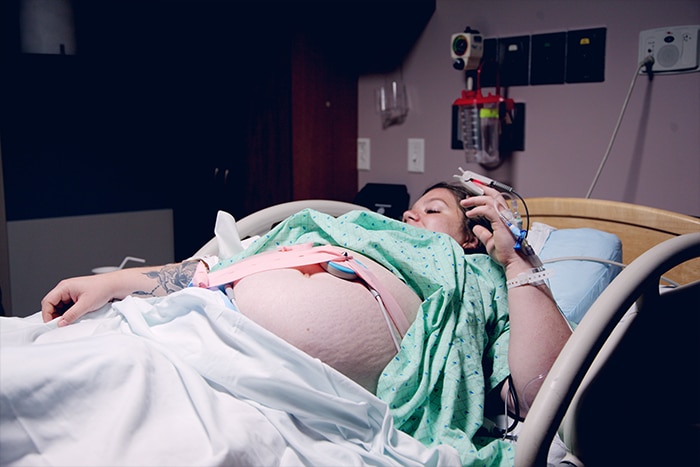 Woman laying in hospital bed with fetal monitor on