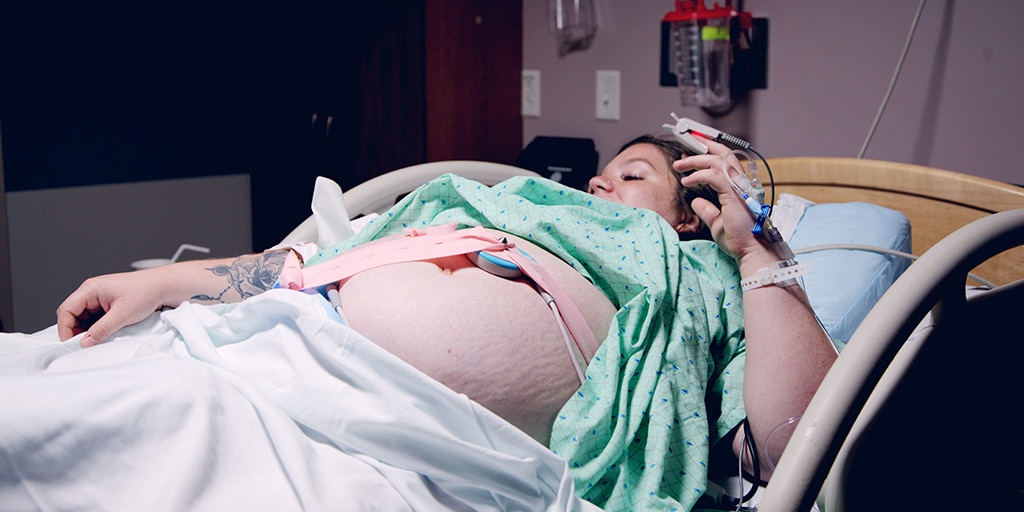 Woman laying in hospital bed with fetal monitor on