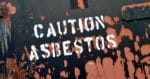 Caution Asbestos sign on rusting container