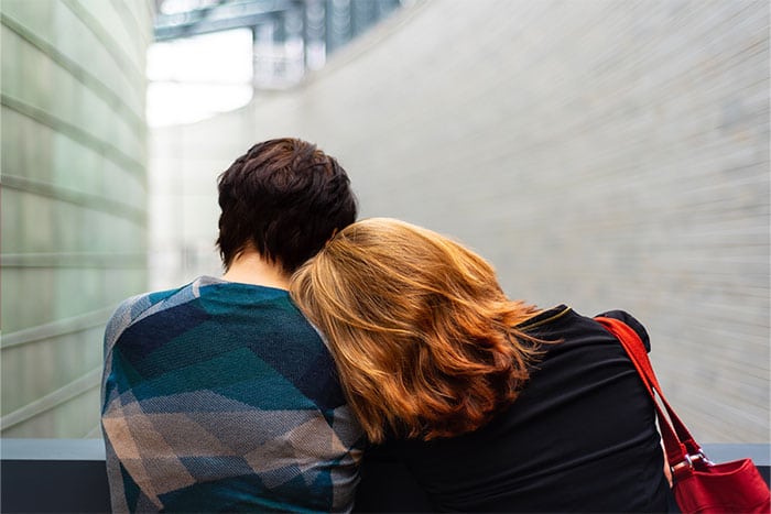 Red headed girllaying her head on a guy's shoulder